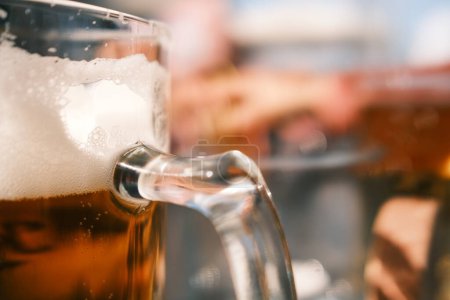 Foto de Primer plano de la cerveza en taza de vidrio sobre una mesa de madera en un pub. - Imagen libre de derechos
