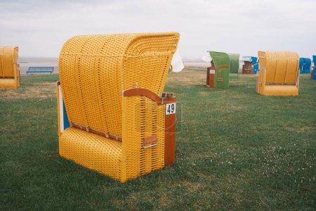 acogedoras sillas de playa de colores con números en la playa, butjadingen, Alemania