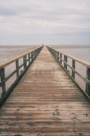 wooden pier on the sea coast at cloudy day 