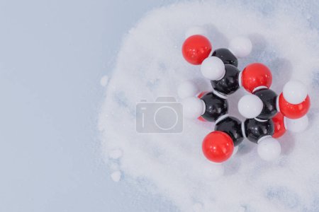 Téléchargez les photos : Molécule de glucose isolée fabriquée par modèle moléculaire sur sucre blanc. C6H12O6 formule chimique de sucre avec des atomes colorés et des liaisons - en image libre de droit