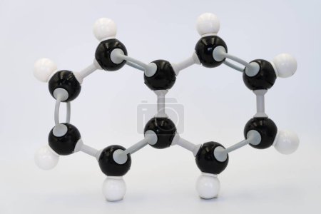 Foto de Molécula de naftaleno (o naftalina) fabricada por modelo molecular sobre fondo blanco. Fórmula química con átomos y enlaces coloreados - Imagen libre de derechos
