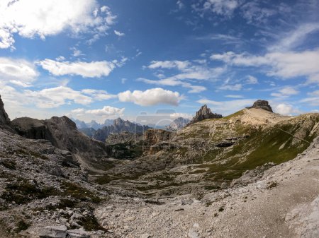 Foto de Una vista panorámica de las altas y desoladas cumbres montañosas en los Dolomitas italianos. Las partes más bajas de las montañas están cubiertas de musgo y hierba. Paisaje crudo y virgen. Un poco nublado.. - Imagen libre de derechos
