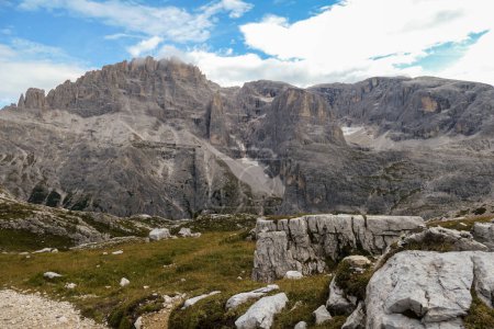 Foto de Vista panorámica del valle en Dolomitas italianas. El fondo del valle está cubierto de pequeñas plantas. En la parte posterior hay una alta cadena montañosa, con pendientes muy pronunciadas. Serenidad y recarga - Imagen libre de derechos