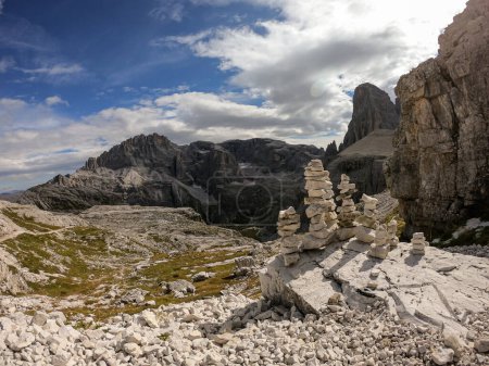 Photo for A field filled with stone men. In the back there are high chains of Italian Dolomites, shrouded in morning haze. The whole area is full of lose stones. Raw and desolated landscape. Solitude - Royalty Free Image