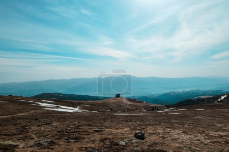 Foto de A vast, golden pasture on top of Sauofen, Austrian Alps. A lot of big stones on the grounds. High mountain chains in the back. Blue sky, with a few clouds. Outdoor activity. Serenity and calmness - Imagen libre de derechos