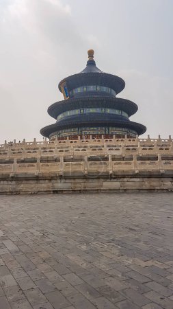 Foto de Temple of Heaven in Beijing, China. The temple is round and surrounded by white fence. The temple is build in the central point of the big complex. No people around. Serenity and calmness. Overcast. - Imagen libre de derechos