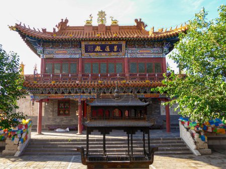 Photo for A two storied Buddhist temple in Fuzhou, Fujian. There is a place for candles in front of the temples. The building is surrounded with green trees. Bright and clear day. Spirituality. - Royalty Free Image