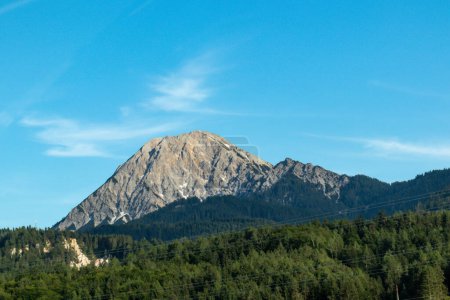 Photo for A close up view on Dobratsch - an Alpine mountain in Austria. The mountain is very high and barren. dense forest underneath. Clear and blue sky above. - Royalty Free Image