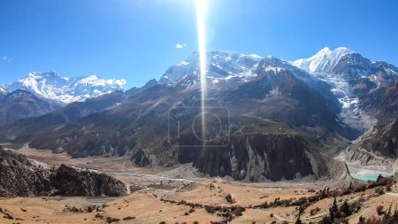Foto de A panoramic view on Manang valley from Praken Gompa, Nepal. High Himalayan ranges around. There is a small lake in the valley. Snow capped peaks of Annapurna Chain. Harsh landscape. - Imagen libre de derechos