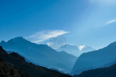 Téléchargez les photos : Chaînes himalayennes enveloppées de brouillard, vues de Thorung Phedi, Annapurna Circuit Trek, Nepal. Il y a plusieurs chaînes de montagnes. Rayons de soleil traversant les sommets. L'heure dorée. Méditation et sérénité - en image libre de droit