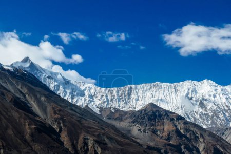 Foto de Una vista de cerca de las altas cumbres nevadas del Himalaya a lo largo de Annapurna Circuit Trek en Nepal. Pendientes áridas y afiladas. Exploración y descubrimiento de nuevos lugares. - Imagen libre de derechos