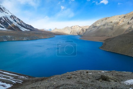 Téléchargez les photos : Une vue panoramique sur le lac Tilicho de couleur turquoise en Himalaya, région de Manang au Népal. Le lac d'altitude le plus élevé du monde (4949m). La neige recouvrait les montagnes. Surface calme du lac. Sérénité - en image libre de droit