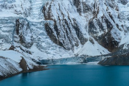 Téléchargez les photos : Vue rapprochée sur le lac Tilicho de couleur turquoise en Himalaya, région de Manang au Népal. Le lac d'altitude le plus élevé du monde (4949m). La neige recouvrait les montagnes. Surface calme du lac. Sérénité - en image libre de droit