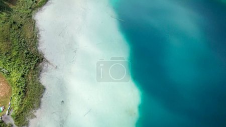 Photo for A top down, drone capture of Weissensee lake in Austrian Alps. The water changes color from white, turquoise to navy blue. Green shore of the lake. A bit of overcast. Serenity and peacefulness - Royalty Free Image