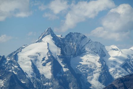 Foto de Un primer plano de Grossglockner, el punto más alto de Austria. La montaña está cubierta de nieve. Toda la zona es muy empinada y peligrosa, con muchas piedras perdidas. Día soleado. Expedición y logro - Imagen libre de derechos