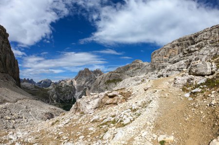 Foto de Una vista panorámica de los Dolomitas en Italia. Hay fuertes y empinadas laderas de montaña alrededor. Muchos pierden piedras y guijarros. El cielo está lleno de nubes suaves. Paisaje crudo. Serenidad y calma - Imagen libre de derechos