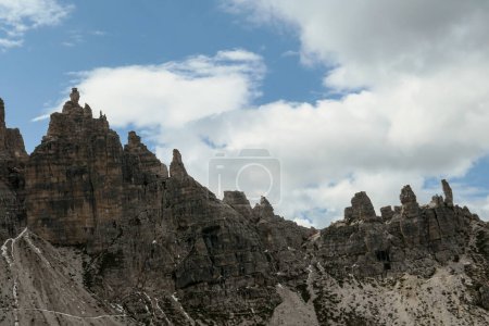 Foto de Una vista cercana de los picos altos y agudos de los Dolomitas en Italia. El cielo está lleno de nubes suaves. Muchos pierden piedras y guijarros. Paisaje crudo y desolado. Serenidad y calma - Imagen libre de derechos