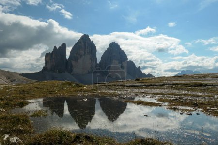 Foto de Una vista panorámica de la famosa Tre Cime di Lavaredo (Drei Zinnen), montañas en Dolomitas italianas. Las montañas se reflejan en pequeñas palas. Paisaje desolado y crudo. Fenómeno natural - Imagen libre de derechos