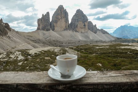 Foto de Una taza de café con vistas al famoso Tre Cime di Lavaredo (Drei Zinnen) en Dolomitas italianas. Las montañas están rodeadas de densas nubes. Disfrutando el momento. Relajación y frío. - Imagen libre de derechos