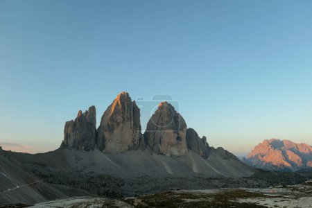 Photo for Golden hour in the Tre Cime region, Italian Dolomites. The mountains are shining with pink and orange. Sunrise in high mountains. Morning haze. Lower parts of the valley covered with shadow. New day - Royalty Free Image