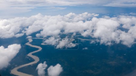 Téléchargez les photos : A long river in Gunung Mulu National Park Malayasia seen from the plane. Sky is covered with clouds, the river is winding with many bends, brownish in color. The banks are surrounded by a thick forest - en image libre de droit