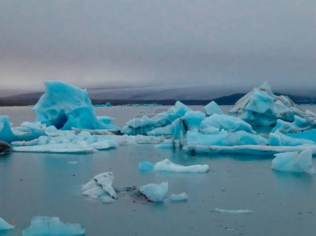 Foto de Laguna Glaciar. Bergs de hielo azul hielo a la deriva en la superficie de una laguna. Se dirigen hacia la sede. El calentamiento global causando que el glaciar se encoja y se derrumbe. Fondo suave. Frío y soledad. - Imagen libre de derechos
