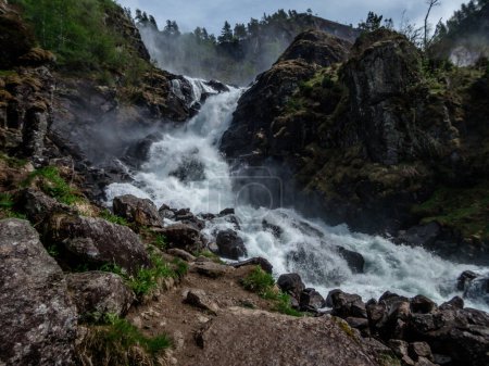 Photo for Upper parts of Langfossen waterfall at its splendid. Vast and tall waterfall, flowing around the rocks and in between the trees. Immense power of the nature. The water falls down a towering mountain - Royalty Free Image
