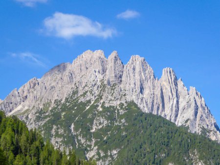 Téléchargez les photos : Massive, forte chaîne de montagnes pierreuses de Lienz Dolomites, Autriche. La montagne a une forme pyramidale, elle est partiellement envahie par des buissons verts. Alpinisme dangereux.Journée claire et belle. - en image libre de droit