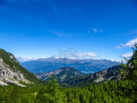 Téléchargez les photos : Un magnifique panorama des Dolomites à Lienz, Autriche. La chaîne de montagnes se propage sans fin. Peu de nuages au-dessus des sommets. Arbres verts et buissons envahissant les pentes. - en image libre de droit