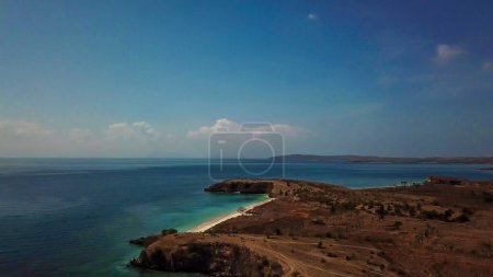 Téléchargez les photos : A panoramic view on an idyllic Pink Beach on Lombok, Indonesia. Sea is calm, shining with many shades of blue. Beauty in the nature. Unspoiled, hidden gem. Perfect place for peaceful, relaxed holidays - en image libre de droit