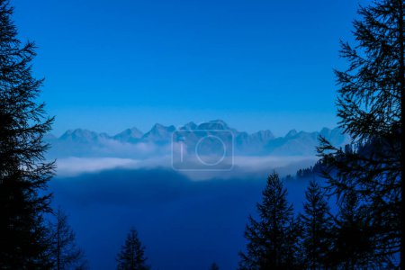 Téléchargez les photos : Une chaîne de montagnes lunatique des Dolomites de Lienz, en Autriche, cachée dans la brume. La vallée est entourée de brouillard. Escalade en haute montagne. Liberté et solitude. Il n'y a pas de nuages dans les parties supérieures - en image libre de droit