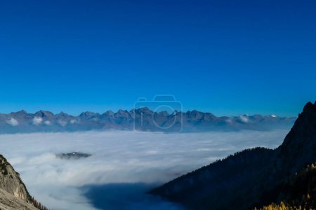 Téléchargez les photos : Vue panoramique sur les Dolomites de Lienz, Autriche depuis le sommet de Grosse Gamswiesenspitze, se baignant au soleil du matin. La vallée est entourée de brouillard. Escalade en haute montagne. Liberté et solitude - en image libre de droit