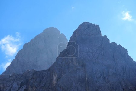 Téléchargez les photos : Un énorme mur de montagne dominant la forêt dans les Dolomites de Lienz, en Autriche. Les pentes des montagnes sont stériles, pointues et dangereuses. Escalade en haute montagne. Liberté et solitude. - en image libre de droit