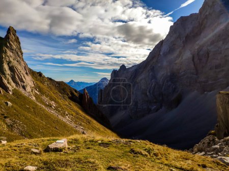 Photo for A drone shot of Alpine landscape of Austria. Sharp slopes of both side of the valley. Hard to reach mountain peaks. There are many mountain ranges in the back. Serenity and calmness - Royalty Free Image