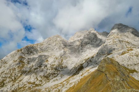 Photo for Golden colored mountains range at Austrian-Italian border. The autumn vibes in Alps, nature getting ready for hibernation. Sharp rocky Alpine peaks. Serenity and peace. Clouds breaching high mountains - Royalty Free Image