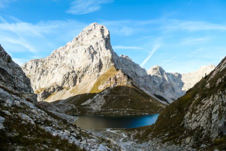 Photo for Panoramic shot of a soft reflection of an Alpine mountain in Wolayer Lake, Austria. Completely still surface of the lake. Mountain is surrounded by morning haze. Peace of mind, calmness. - Royalty Free Image