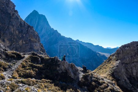 Téléchargez les photos : Une femme avec un sac à dos de randonnée et un casque se reposer pendant la randonnée pour atteindre la Grosse Gamswiesenspitze à Lienz Dolomites, Autriche. Des pentes vives et dangereuses. Montagnes alpines massives. Solo vagabond - en image libre de droit