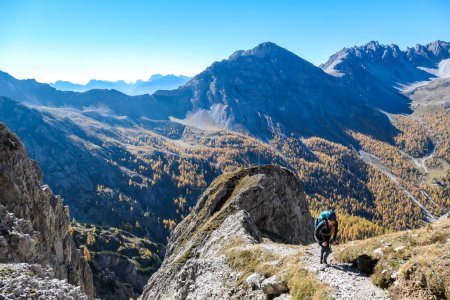 Téléchargez les photos : Une femme avec un grand sac à dos de randonnée marchant sur un sentier pour atteindre la Grosse Gamswiesenspitze à Lienz Dolomites, Autriche. Des pentes vives. Montagnes alpines massives. Errant seul, contemplant la nature - en image libre de droit