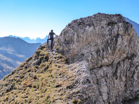 Téléchargez les photos : Homme avec sac à dos de randonnée marchant à bout pointu sur le chemin de la Grosse Gamswiesenspitze, Lienz Dolomites, Autriche. Solo errant dans les Alpes. Admirer la beauté de la nature. Aventure et liberté - en image libre de droit