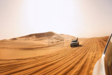 Foto de Aventura del desierto: 4x4 en movimiento con el excitado pasajero inclinado por la ventana - Imagen libre de derechos