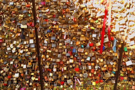 Background with padlocks attached to a grate as a token of love. 22 October 2024 Borghetto sul Mincio, Veneto - Italy