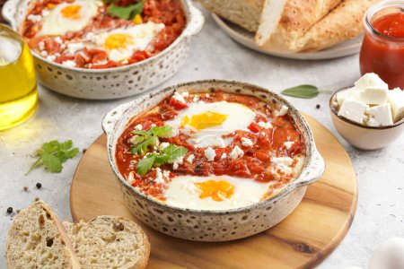 Photo for Traditional north african dish shakshouka made of eggs poached in a sauce of tomatoes, olive oil, bell peppers, onion and garlic, spiced with cumin, paprika and cayenne pepper - Royalty Free Image