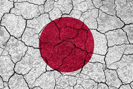 Téléchargez les photos : Tremblements de terre au Japon, drapeau du Japon sur un mur avec des fissures d'un tremblement de terre - en image libre de droit