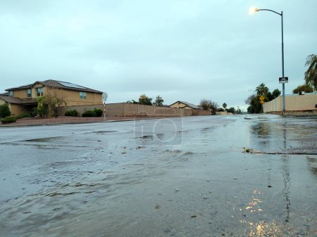 Téléchargez les photos : Winter morning rain brings waves of running flood waters with dirty air bubbles to city streets limiting availability of dedicated bike lanes, Phoenix, Arizona - en image libre de droit