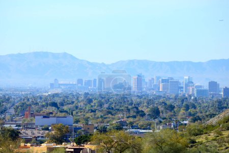 High rise buildings of Phoenix downtown in the Valley of the Sun with a backdrop of South Mountains as seen from North Mountain Park hiking trails on a sunny Spring morning, Arizona