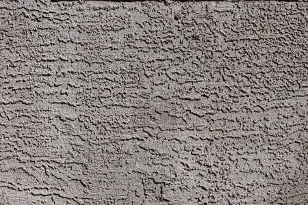 Photo for Decorative dark-brown lace and skip coarse sand stucco finish applied to external wall, background or photographic backdrop, closeup - Royalty Free Image