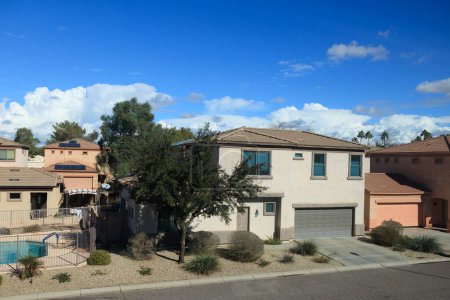 Arizona típico barrio residencial durante el cálido invierno con la formación lenta de nubes cúmulos contra el cielo azul