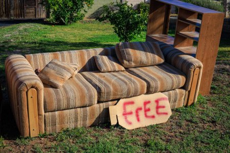 Muebles usados gratis para ir a otros propietarios al aire libre en un césped verde durante la limpieza de primavera en Phoenix, Arizona