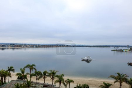 Gloomy cloudy morning hanging over mirror-like still water surface of Sail Bay in San Diego, Southern California