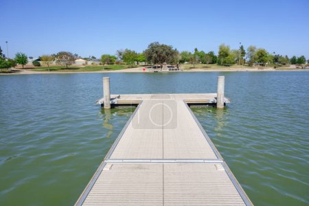 Double sided boat dock stretching into cool spring waters of Kiwanis park lake, Tempe, Arizona 